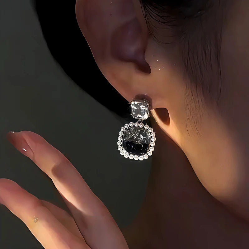 Model showcasing the dangle and style of the 14K Gold-Plated Zircon Black Crystal Earrings