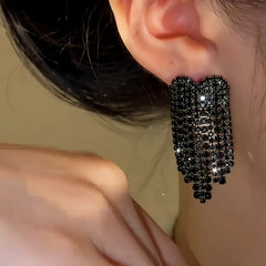 Model showcasing the dangle and style of the 14K Gold-Plated Zircon Black Diamond Heart Tassel Earrings