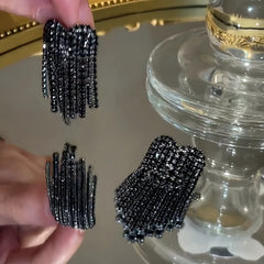 Angled view of the 14K Gold-Plated Zircon Black Diamond Heart Tassel Earrings