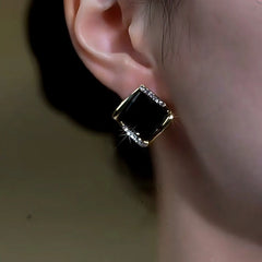 Model showcasing the dangle and style of the 14K Gold-Plated Zircon Black Diamond Stud Earrings