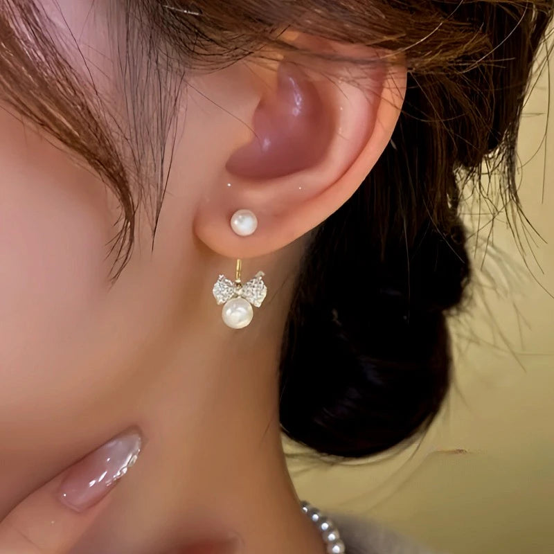 Model showcasing the dangle and style of the 14K Gold-Plated Zircon Bow Bead Jacket Earrings