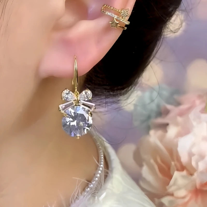 Model showcasing the dangle and style of the 14K Gold-Plated Zircon Bow Ear Hooks