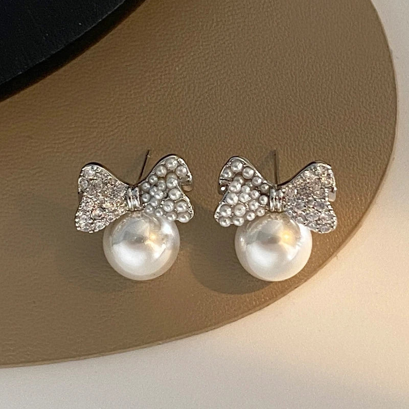 Angled view of the 14K Gold-Plated Zircon Bow Pearl Stud Earrings