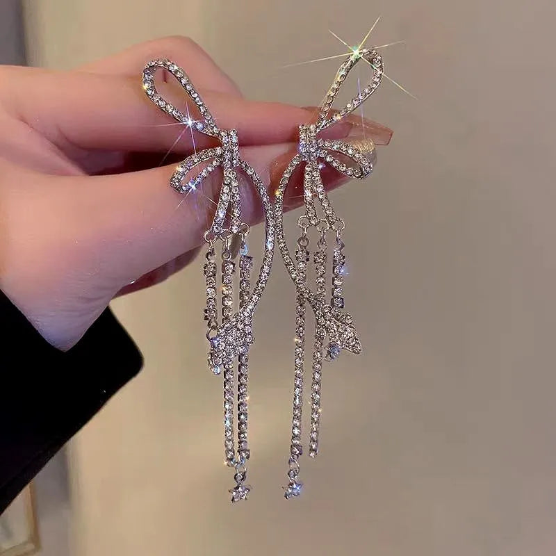 Angled view of the 14K Gold-Plated Zircon Bow Tassel Earrings