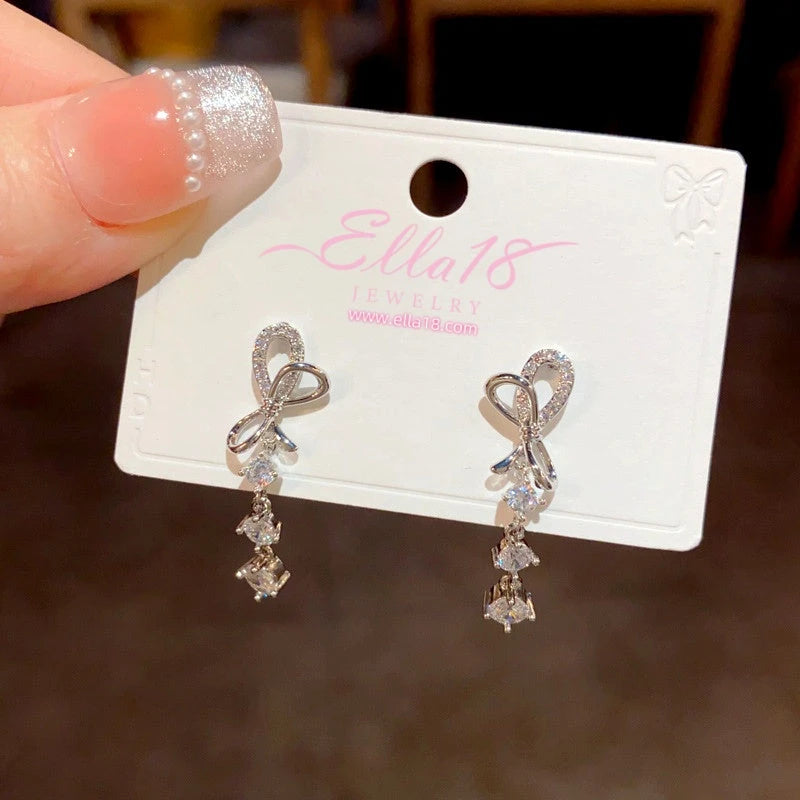 Angled view of the 14K Gold-Plated Zircon Bow Tassel Earrings