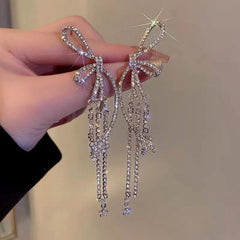 Angled view of the 14K Gold-Plated Zircon Bow Tassel Earrings