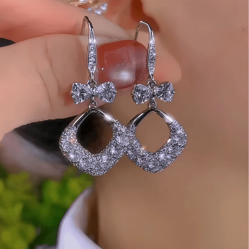 Model showcasing the dangle and style of the 14K Gold-Plated Zircon Bow Water Drop Ear Hook Earrings