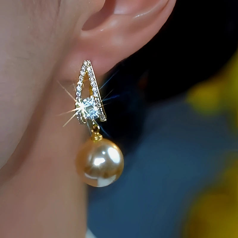 Model showcasing the dangle and style of the 14K Gold-Plated Zircon Brown Pearl Earrings