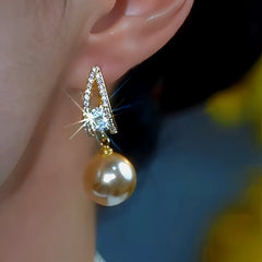 Model showcasing the dangle and style of the 14K Gold-Plated Zircon Brown Pearl Earrings