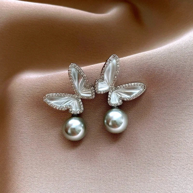 Angled view of the 14K Gold-Plated Zircon Butterfly Gray Pearl Earrings