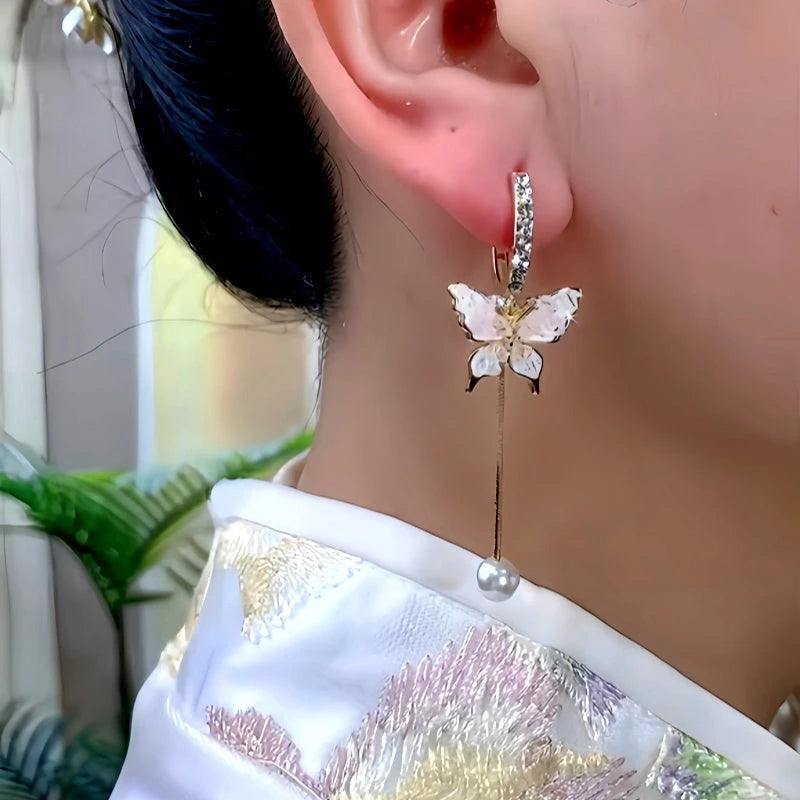 Model showcasing the dangle and style of the 14K Gold-Plated Zircon Butterfly Pearl Earrings