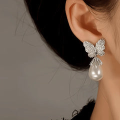 Model showcasing the dangle and style of the 14K Gold-Plated Zircon Butterfly Pearl Earrings