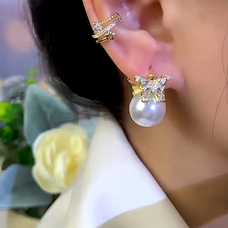 Model showcasing the dangle and style of the 14K Gold-Plated Zircon Butterfly Pearl Earrings