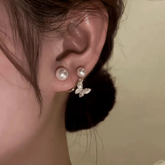 Model showcasing the dangle and style of the 14K Gold-Plated Zircon Butterfly Pearl Jacket Earrings