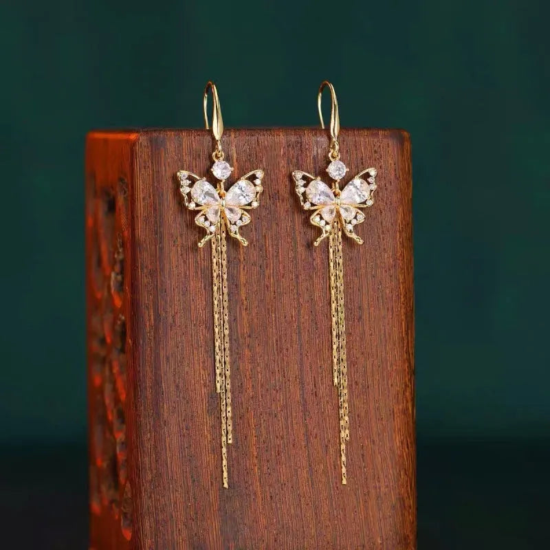 Model showcasing the dangle and style of the 14K Gold-Plated Zircon Butterfly Tassel Earrings