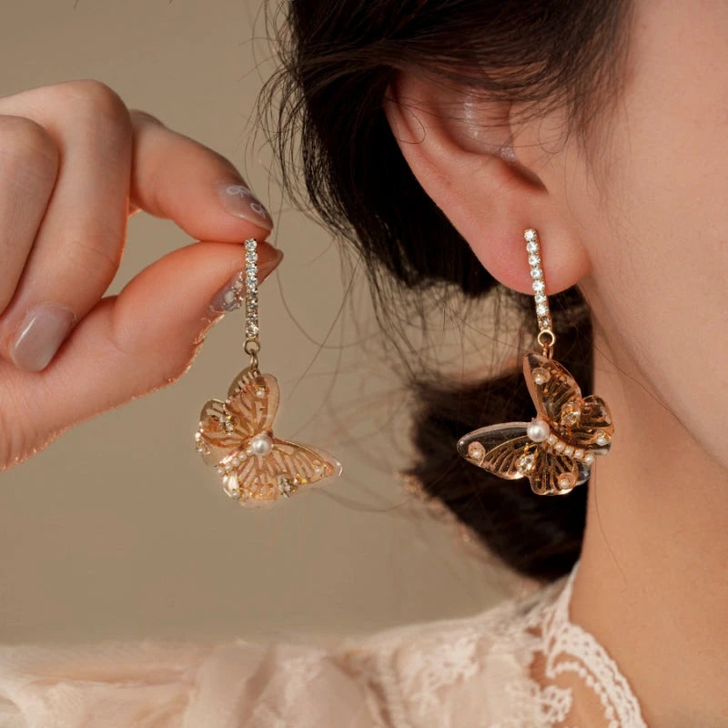 Model showcasing the dangle and style of the 14K Gold-Plated Zircon Butterfly Tassel Earrings