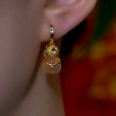 Model showcasing the dangle and style of the 14K Gold-Plated Zircon Cat's Eye Champagne Diamond Ball Durian Earrings