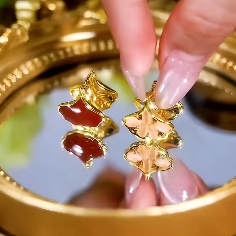 Model showcasing the dangle and style of the 14K Gold-Plated Zircon Cat's Eye Ginkgo Leaf Earrings