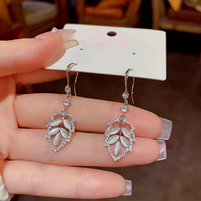 Model showcasing the dangle and style of the 14K Gold-Plated Zircon Cat's Eye Leaf Ear Hook Earrings