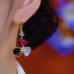 Model showcasing the dangle and style of the 14K Gold-Plated Zircon Cat's Eye Petal Flower Earrings