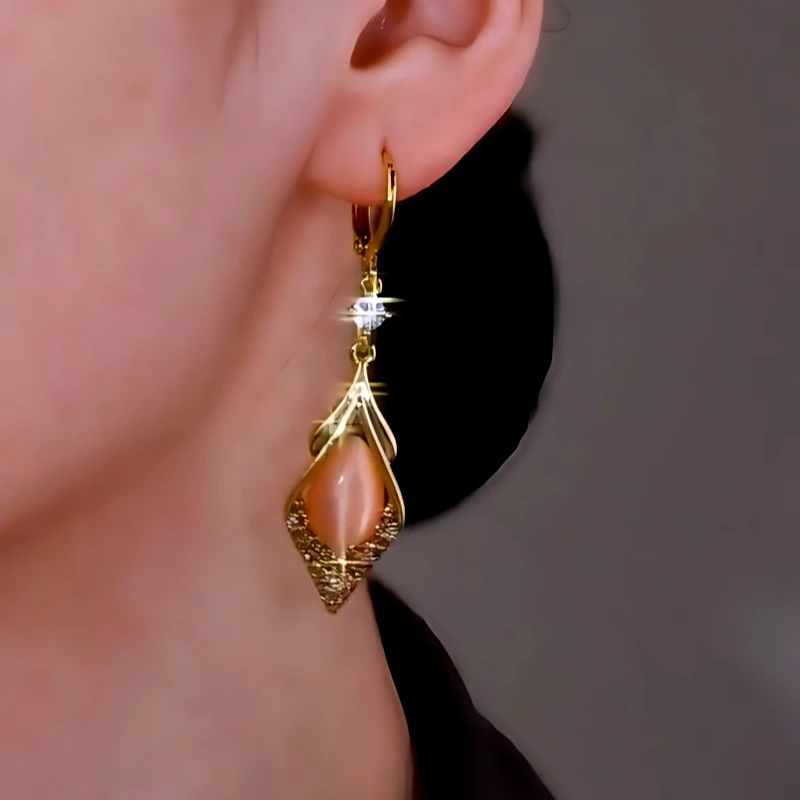 Model showcasing the dangle and style of the 14K Gold-Plated Zircon Cat's Eye Stone Earrings