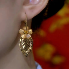 Model showcasing the dangle and style of the 14K Gold-Plated Zircon Cat's Eye Stone Flower Earrings