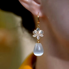 Model showcasing the dangle and style of the 14K Gold-Plated Zircon Cat's Eye Stone Flower Water Drop Earrings