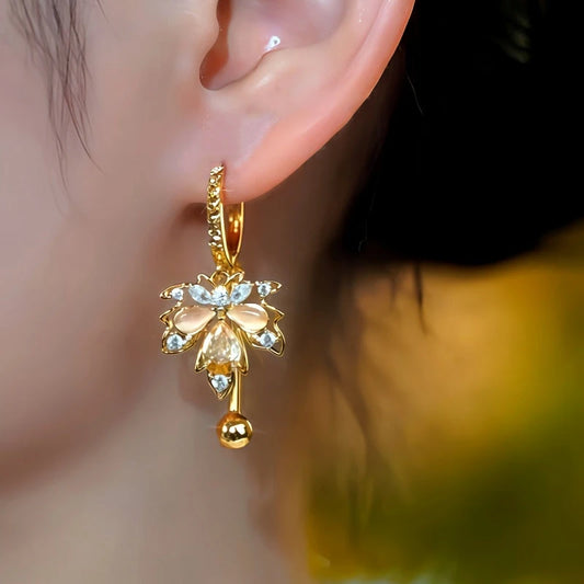 Model showcasing the dangle and style of the 14K Gold-Plated Zircon Cat's Eye Stone Maple Leaf Earrings
