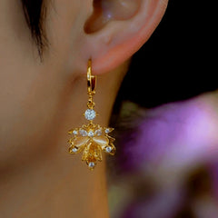 Model showcasing the dangle and style of the 14K Gold-Plated Zircon Cat's Eye Stone Maple Leaf Earrings