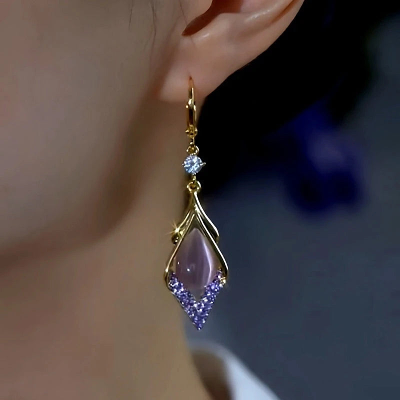Model showcasing the dangle and style of the 14K Gold-Plated Zircon Cat's Eye Stone Water Drop Earrings