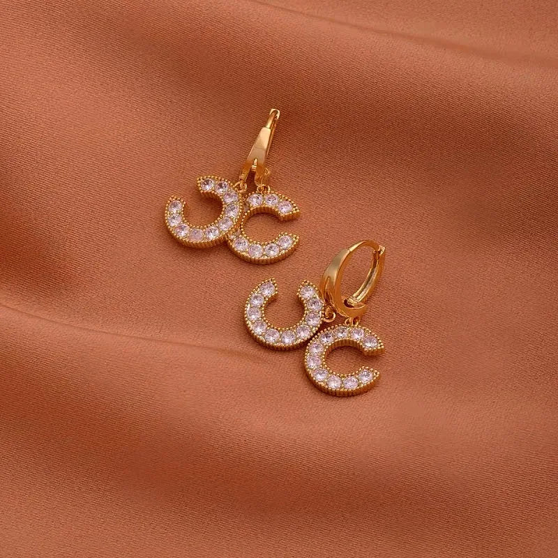 Model showcasing the dangle and style of the 14K Gold-Plated Zircon Chanel Style Double C Earrings
