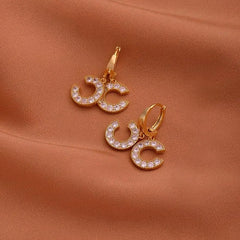 Model showcasing the dangle and style of the 14K Gold-Plated Zircon Chanel Style Double C Earrings
