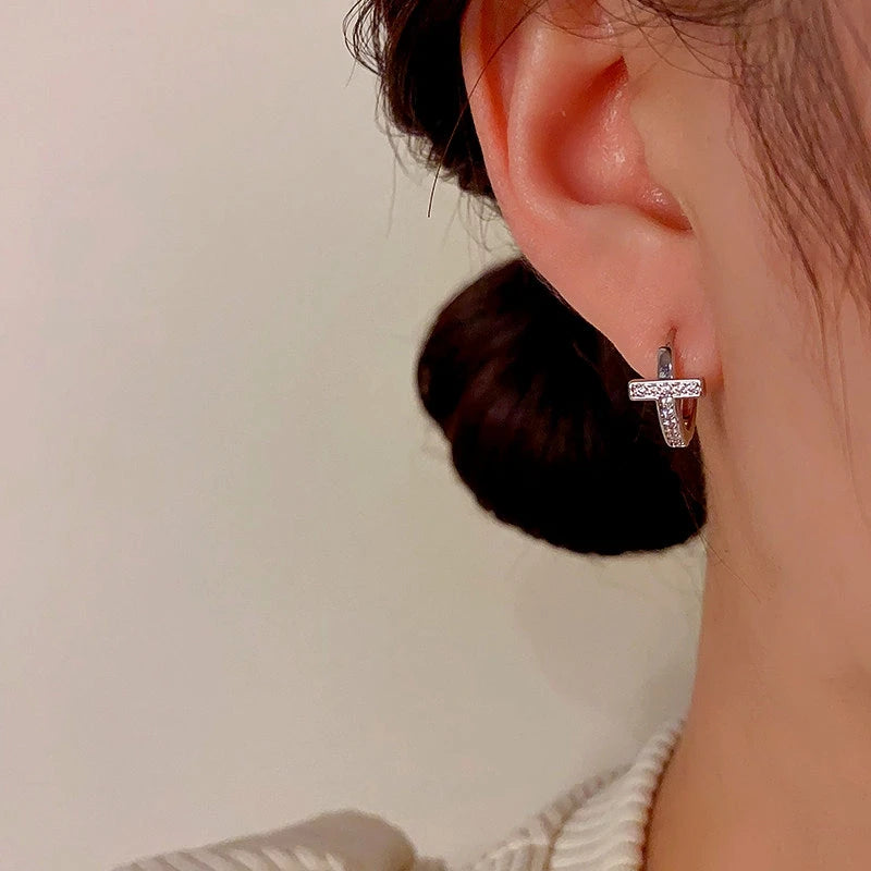Model showcasing the dangle and style of the 14K Gold-Plated Zircon Cross Hoop Earrings