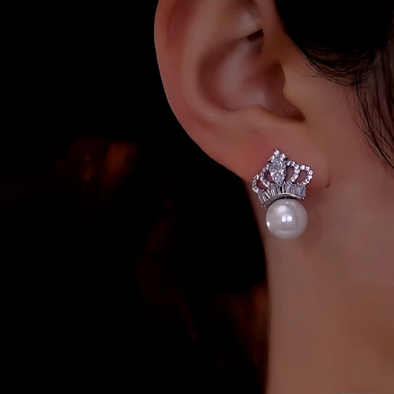 Model showcasing the dangle and style of the 14K Gold-Plated Zircon Crown Pearl Earrings
