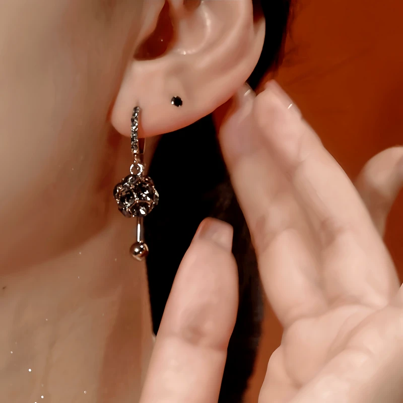 Model showcasing the dangle and style of the 14K Gold-Plated Zircon Crystal Ball Earrings