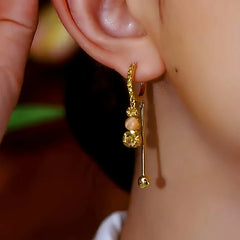 Angled view of the 14K Gold-Plated Zircon Crystal Ball Tassel Earrings