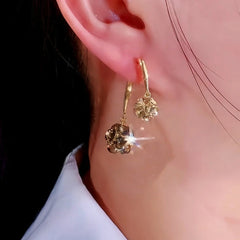 Model showcasing the dangle and style of the 14K Gold-Plated Zircon Diamond Ball Earrings