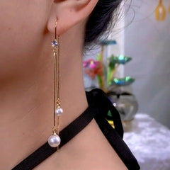 Model showcasing the dangle and style of the 14K Gold-Plated Zircon Diamond Bead Threader Tassel Earrings