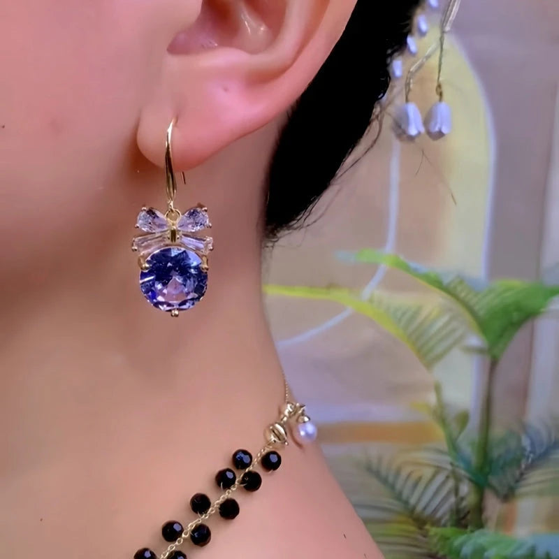 Model showcasing the dangle and style of the 14K Gold-Plated Zircon Diamond Bow Ear Hook Earrings