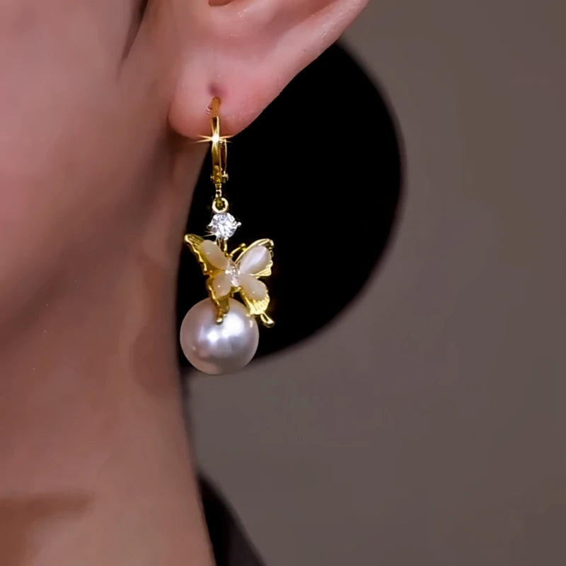 Model showcasing the dangle and style of the 14K Gold-Plated Zircon Diamond Butterfly Pearl Earrings
