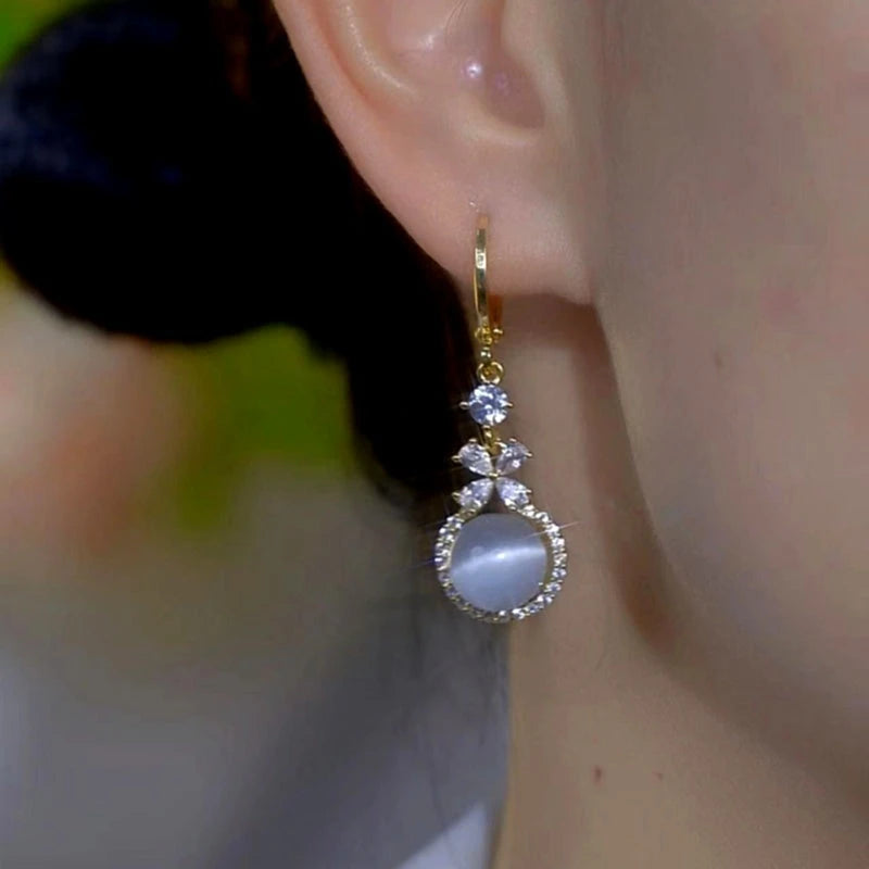 Model showcasing the dangle and style of the 14K Gold-Plated Zircon Diamond Cat's Eye Bead Earrings