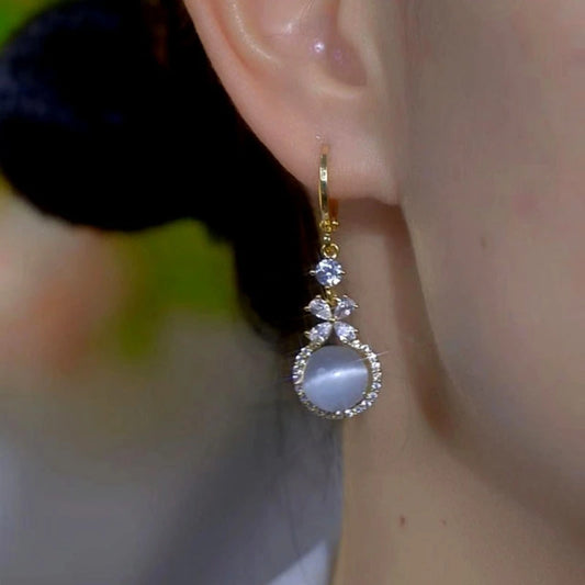 Model showcasing the dangle and style of the 14K Gold-Plated Zircon Diamond Cat's Eye Bead Earrings