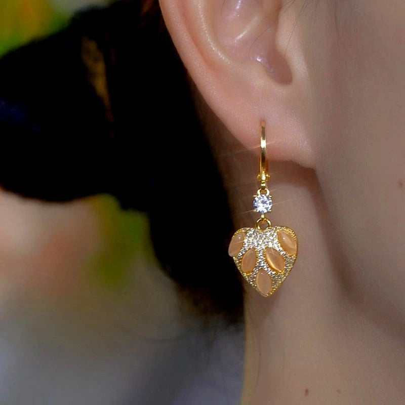 Model showcasing the dangle and style of the 14K Gold-Plated Zircon Diamond Cat's Eye Stone Heart Earrings