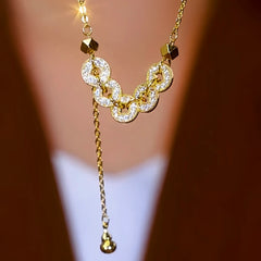 Close-up of the pendant and clasp on the Coin Tassel Necklace