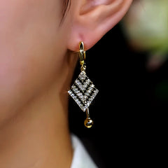 Model showcasing the dangle and style of the 14K Gold-Plated Zircon Diamond Earrings