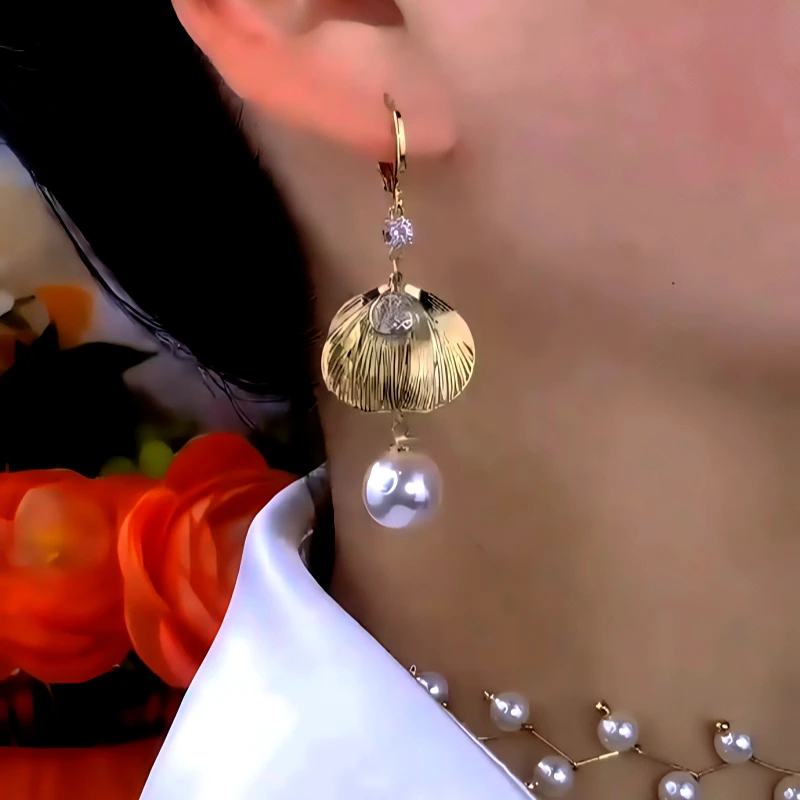 Model showcasing the dangle and style of the 14K Gold-Plated Zircon Diamond Leaf Bead Earrings