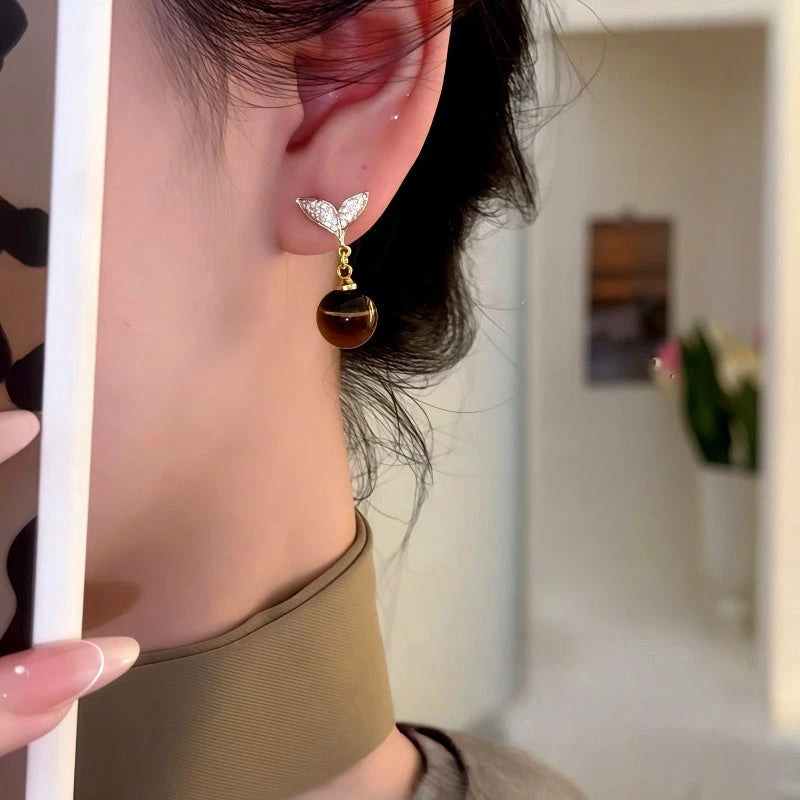Model showcasing the dangle and style of the 14K Gold-Plated Zircon Diamond Mermaid Tail Bead Earrings