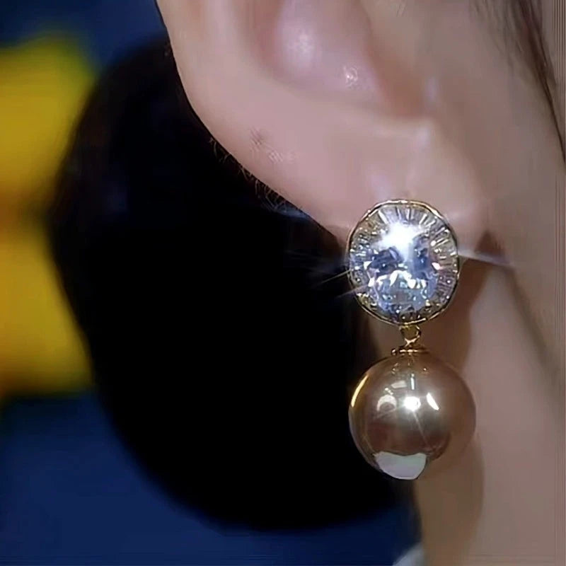 Model showcasing the dangle and style of the 14K Gold-Plated Zircon Diamond Pearl Earrings