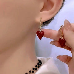 Model showcasing the dangle and style of the 14K Gold-Plated Zircon Diamond Red Heart Earrings