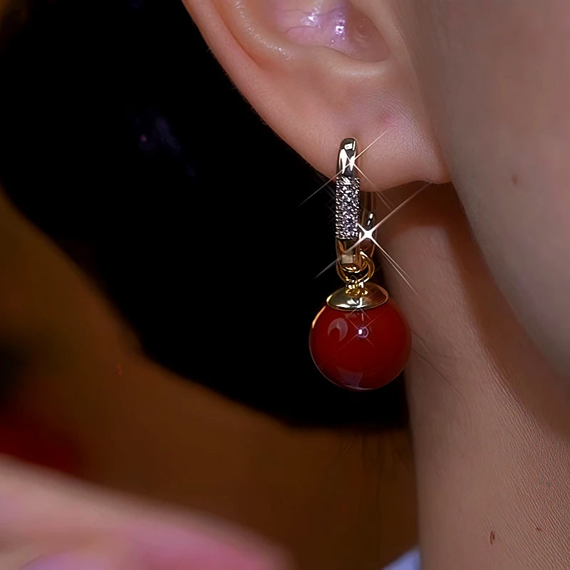 Close-up detail of the sparkling zircons and plating on the Red Drop Earrings